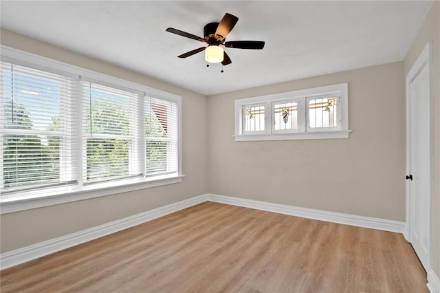 unfurnished room with a ceiling fan, light wood-type flooring, and baseboards