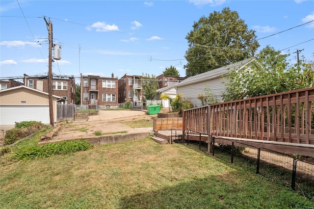 view of yard with a wooden deck, an outdoor structure, fence, and a residential view