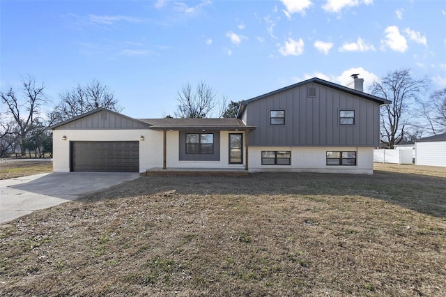 split level home featuring an attached garage, brick siding, driveway, board and batten siding, and a chimney