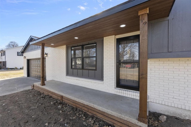 view of home's exterior with a garage, driveway, and brick siding