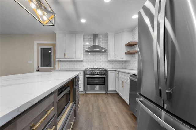 kitchen featuring open shelves, stainless steel appliances, decorative backsplash, wall chimney range hood, and wood finished floors