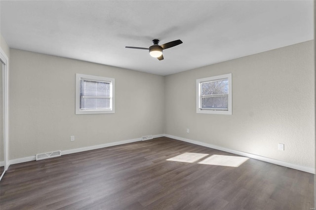 unfurnished room with visible vents, baseboards, and wood finished floors