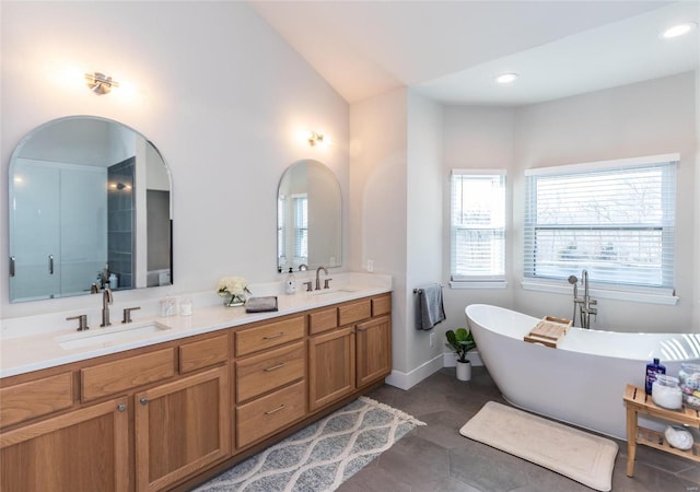 bathroom with a wealth of natural light, a freestanding tub, and a sink