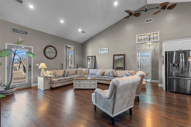 living room featuring high vaulted ceiling, plenty of natural light, visible vents, and dark wood-type flooring