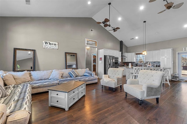 living room with dark wood-style floors, visible vents, high vaulted ceiling, and a ceiling fan