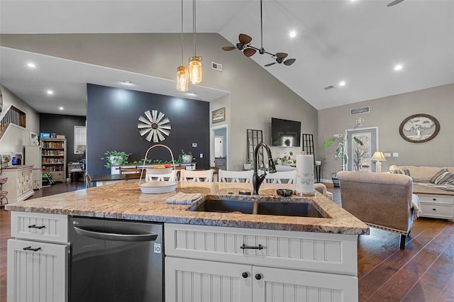 kitchen with dark wood-type flooring, a sink, open floor plan, dishwasher, and a center island with sink