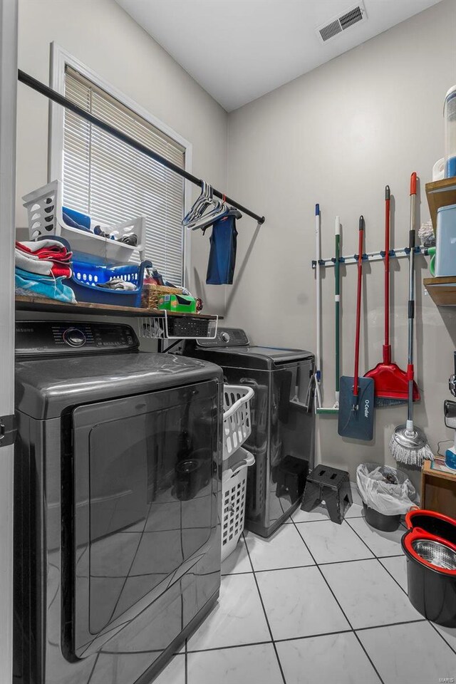 laundry room with laundry area, separate washer and dryer, and visible vents