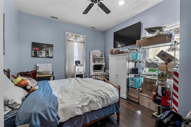 bedroom with a ceiling fan, visible vents, and wood finished floors