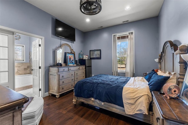 bedroom featuring ensuite bath, visible vents, wood finished floors, and recessed lighting