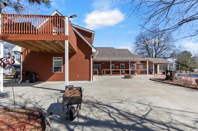 rear view of house featuring a patio area, a fire pit, and a wooden deck