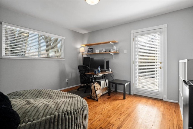 home office with a healthy amount of sunlight, baseboards, and light wood-style floors