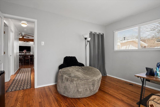 sitting room with visible vents, baseboards, and wood finished floors