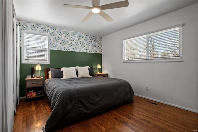 bedroom featuring visible vents, wallpapered walls, baseboards, wood finished floors, and a ceiling fan