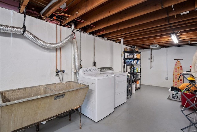 washroom with a sink, washing machine and dryer, and laundry area