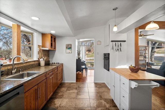 kitchen with dishwasher, black oven, brown cabinets, and a sink