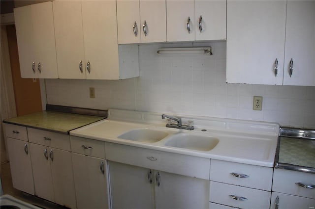 kitchen featuring a sink, light countertops, and backsplash