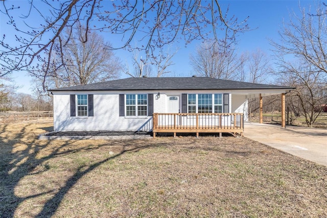 ranch-style house featuring driveway, a carport, a front yard, and brick siding