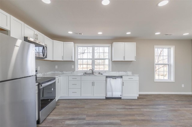 kitchen featuring white cabinetry, visible vents, stainless steel appliances, and a sink