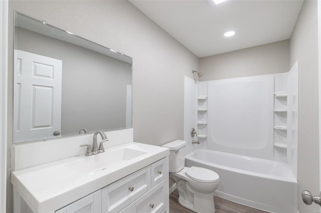 bathroom with washtub / shower combination, vanity, toilet, and wood finished floors