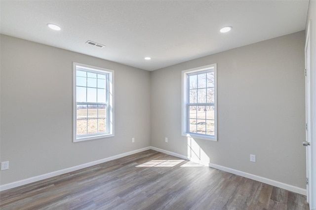 spare room with recessed lighting, wood finished floors, and baseboards