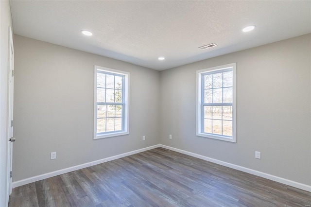 spare room featuring a wealth of natural light, visible vents, and baseboards