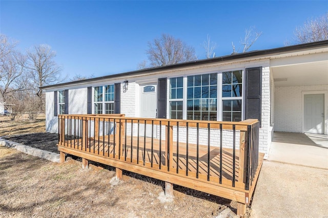 exterior space with brick siding and a wooden deck