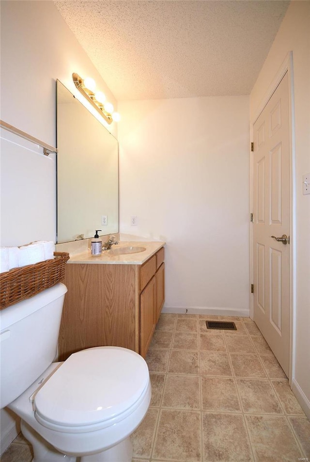 bathroom featuring visible vents, toilet, tile patterned flooring, a textured ceiling, and vanity