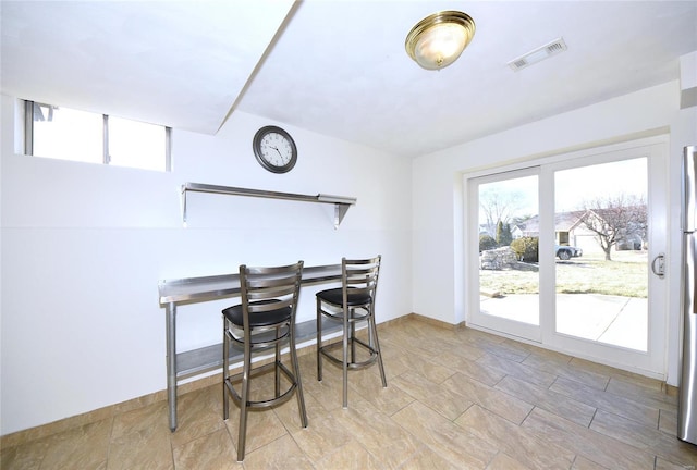 dining space featuring baseboards and visible vents