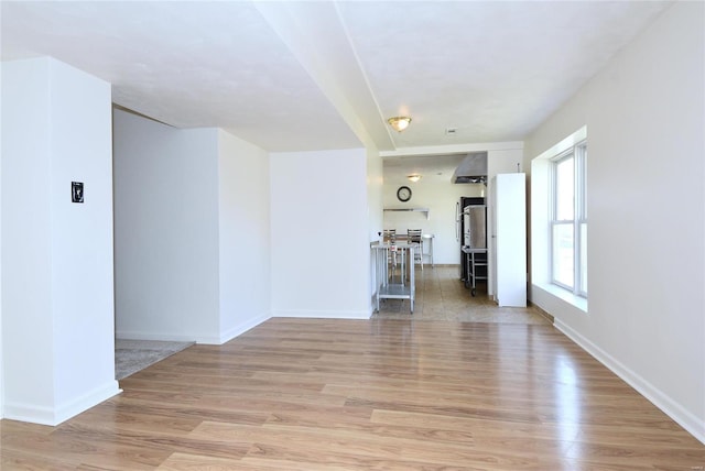 unfurnished room with light wood-type flooring and baseboards