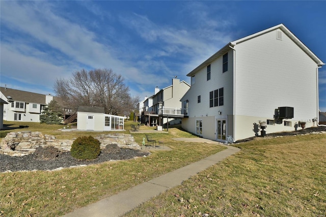 view of property exterior with a residential view, an outbuilding, cooling unit, and a yard