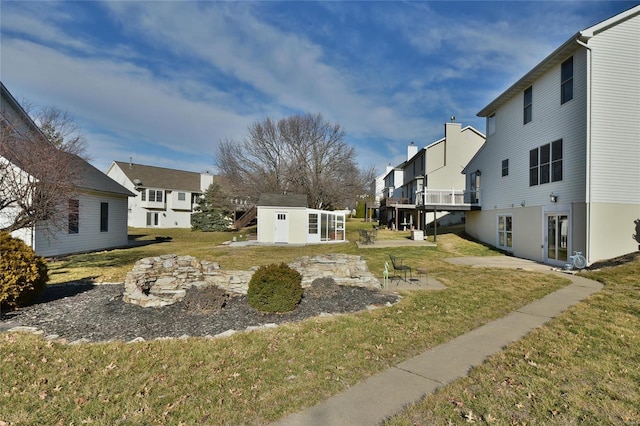 view of yard featuring a residential view, a patio, and an outdoor structure