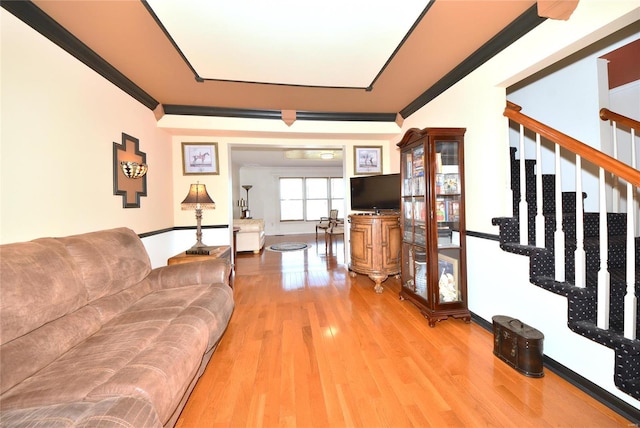 living room with stairs, ornamental molding, and wood finished floors