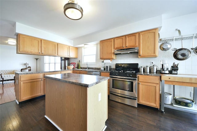 kitchen featuring stainless steel appliances, decorative backsplash, dark wood-type flooring, a peninsula, and under cabinet range hood