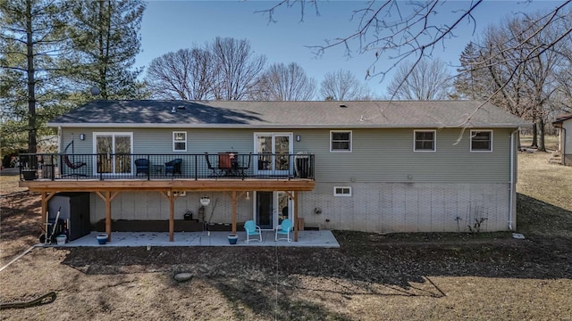 back of property featuring a wooden deck and a patio