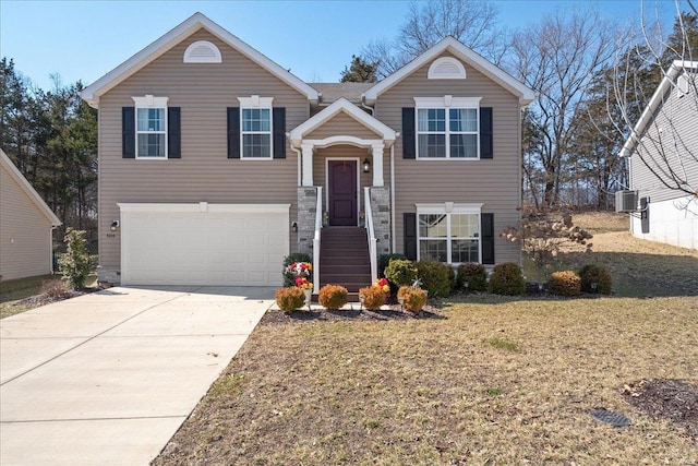 split foyer home featuring a front yard, cooling unit, driveway, and an attached garage