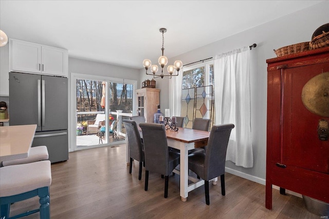 dining area with light wood-style floors, a wealth of natural light, and an inviting chandelier