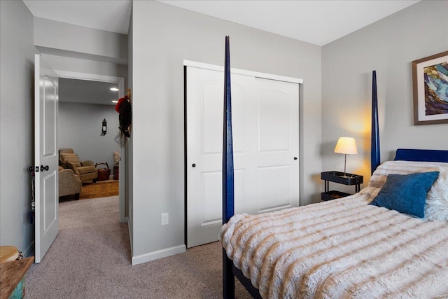 carpeted bedroom featuring baseboards and a closet