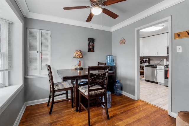 dining room with a ceiling fan, baseboards, crown molding, and wood finished floors