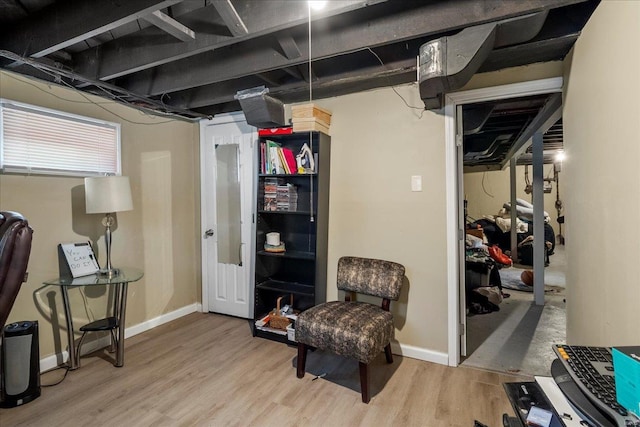 basement with baseboards and wood finished floors