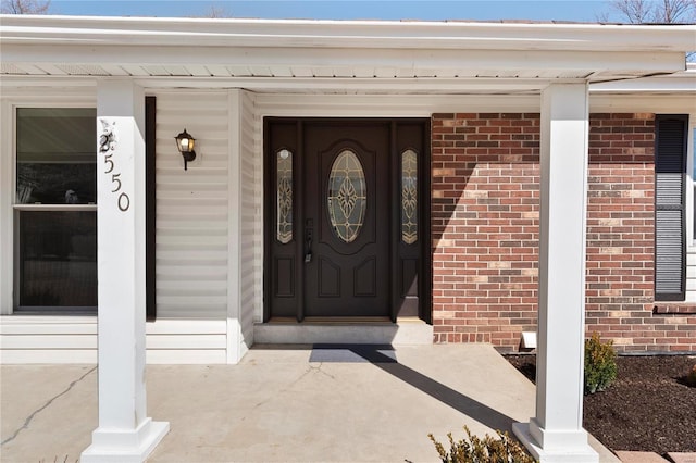 entrance to property featuring brick siding