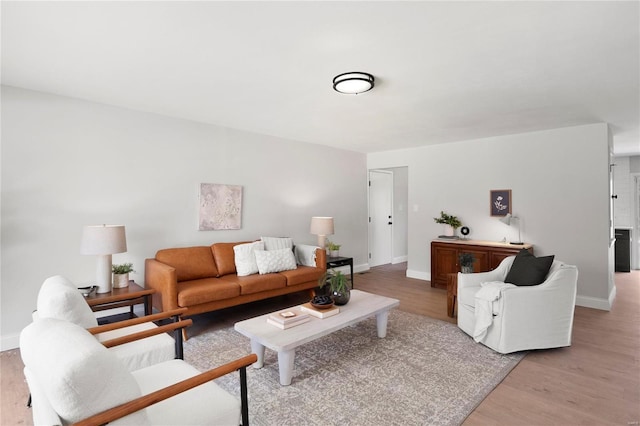 living room featuring baseboards and light wood-type flooring