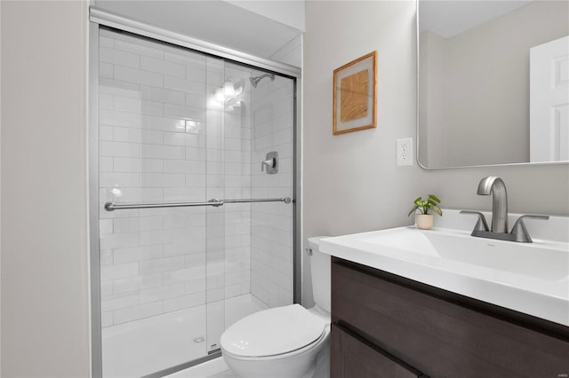 bathroom featuring vanity, toilet, and a shower stall