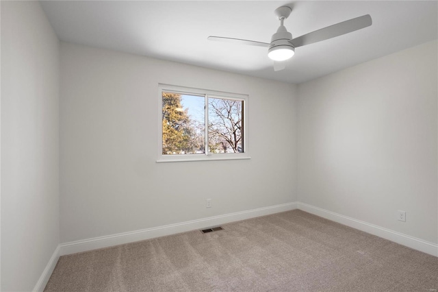 carpeted empty room featuring baseboards, visible vents, and ceiling fan