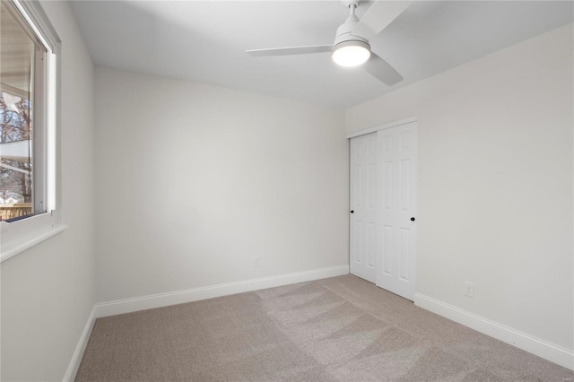 spare room with ceiling fan, baseboards, and carpet