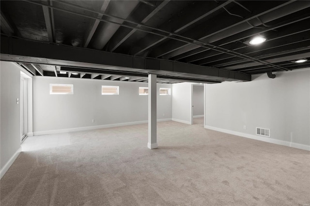 below grade area with visible vents, baseboards, and carpet flooring