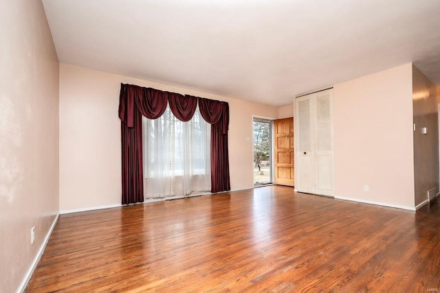 empty room featuring baseboards and wood finished floors