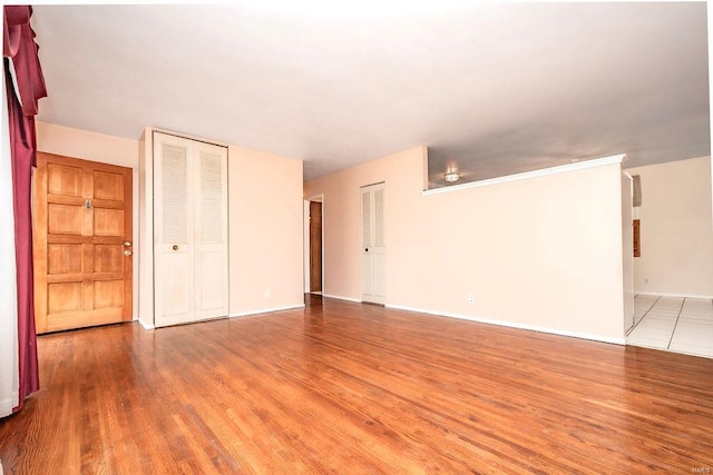 unfurnished room with baseboards and light wood finished floors