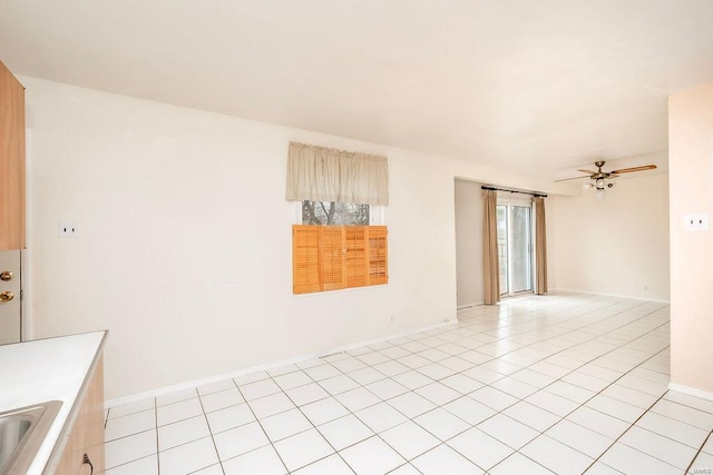 unfurnished room featuring light tile patterned floors, plenty of natural light, ceiling fan, and a sink