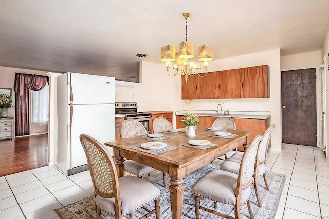 dining room featuring light tile patterned floors, visible vents, and an inviting chandelier