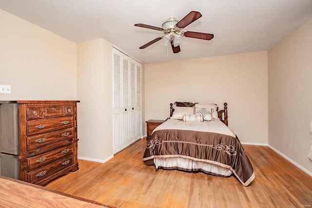 bedroom with a ceiling fan, a closet, light wood-style flooring, and baseboards